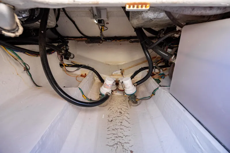 Slide: The Image of 2020 Cobia 350 Center Console bilge area with wiring and plumbing components. - 30