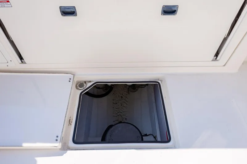 Slide: The Image of 2020 Cobia 350 Center Console boat storage compartment with open hatch. - 34