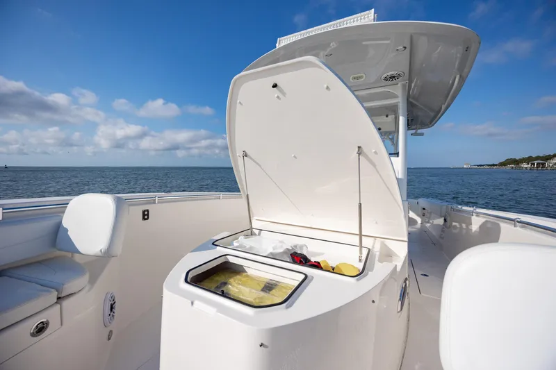 Slide: The Image of 2020 Cobia 350 Center Console boat with open storage compartment on calm sea. - 35