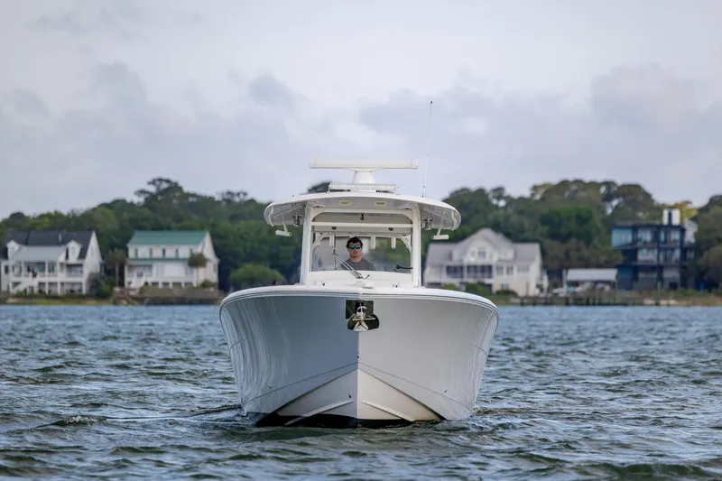 Slide: The Image of 2020 Cobia 350 Center Console boat cruising on a scenic waterway. - 4