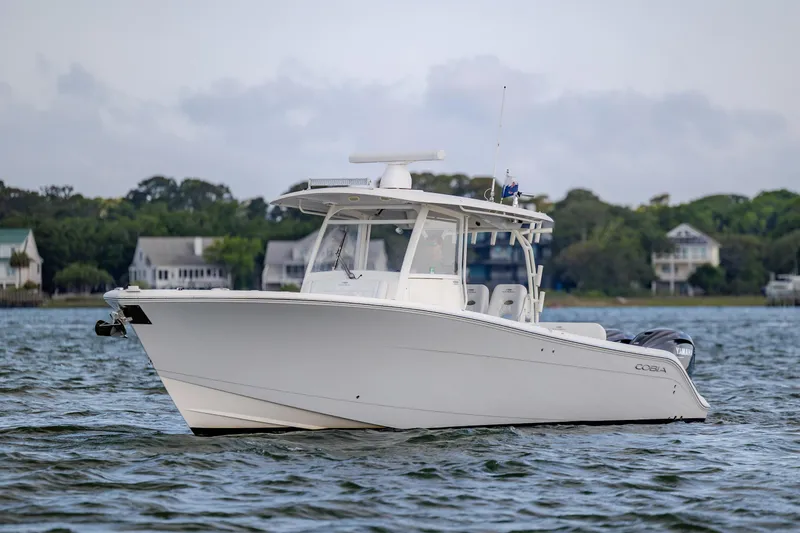 Slide: The Image of 2020 Cobia 350 Center Console boat on calm water near shoreline homes. - 5