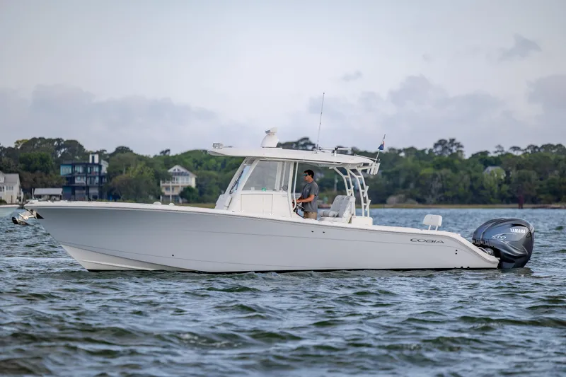 Slide: The Image of 2020 Cobia 350 Center Console boat cruising on a scenic waterway. - 6