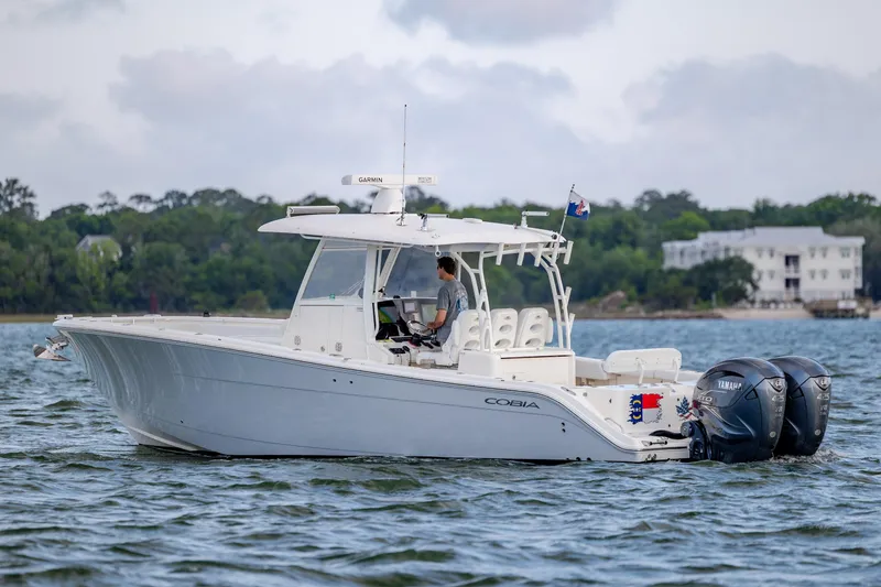 Slide: The Image of 2020 Cobia 350 Center Console boat cruising on a scenic waterway. - 8