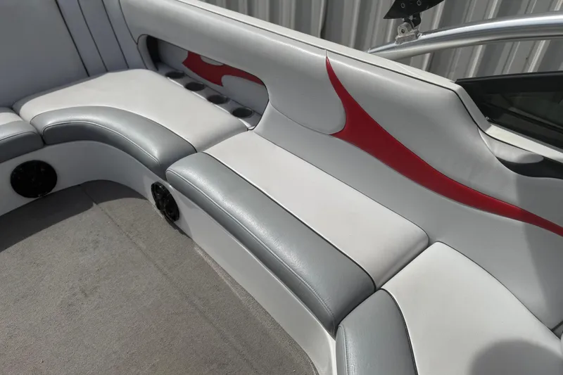 Slide: The Image of 2006 MB SPORTS B52 boat interior with gray and red upholstery, featuring cup holders and speakers. - 12