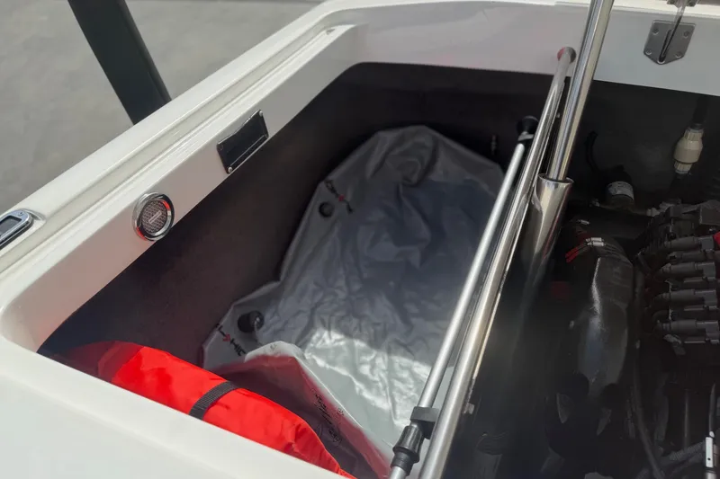 Slide: The Image of 2006 MB SPORTS B52 boat storage compartment with red life jacket and engine components. - 16