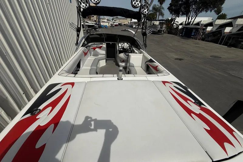 Slide: The Image of 2006 MB SPORTS B52 boat with red and black flame design, docked outdoors. - 7
