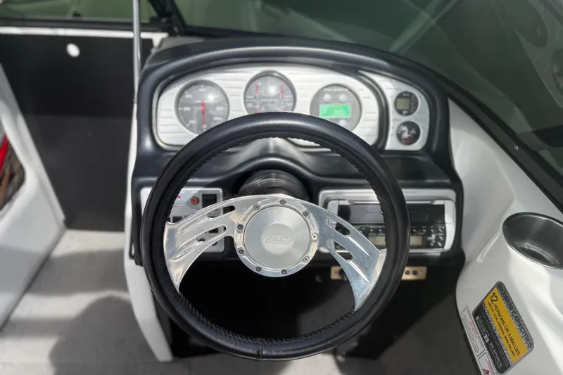 Slide: The Image of Steering wheel and dashboard of a 2006 MB SPORTS B52 boat, featuring gauges and controls. - 8
