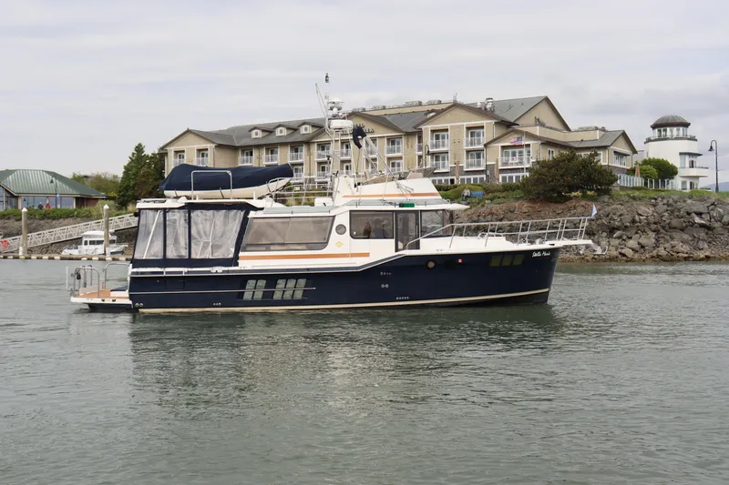 The Image of 2022 Ranger Tugs R-43 CB yacht docked near waterfront buildings. - 0