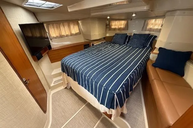 Slide: The Image of Luxurious 2022 Ranger Tugs R-43 CB cabin with striped bedding and modern amenities. - 18