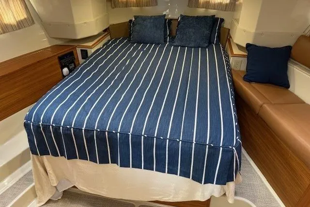Slide: The Image of Cozy cabin interior of 2022 Ranger Tugs R-43 CB with striped bedding and cushions. - 19