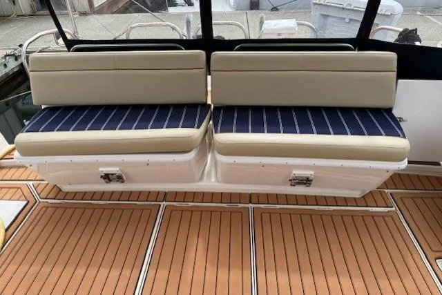 Slide: The Image of 2022 Ranger Tugs R-43 CB boat seating with striped cushions on teak deck. - 27