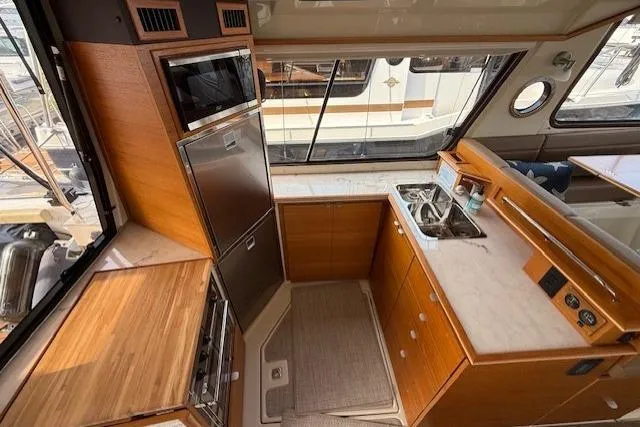 Slide: The Image of Interior of 2022 Ranger Tugs R-43 CB yacht kitchen with wood cabinetry and modern appliances. - 4