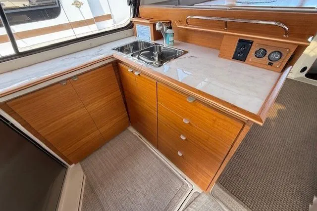 Slide: The Image of Modern kitchen area in 2022 Ranger Tugs R-43 CB boat with wooden cabinetry. - 5