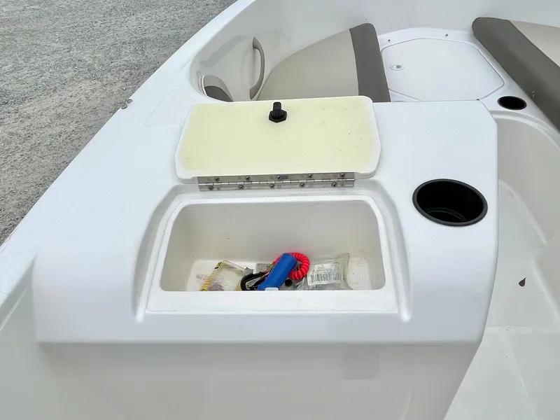 Slide: The Image of 2017 Bayliner E21 boat with open storage compartment and cup holder. - 29