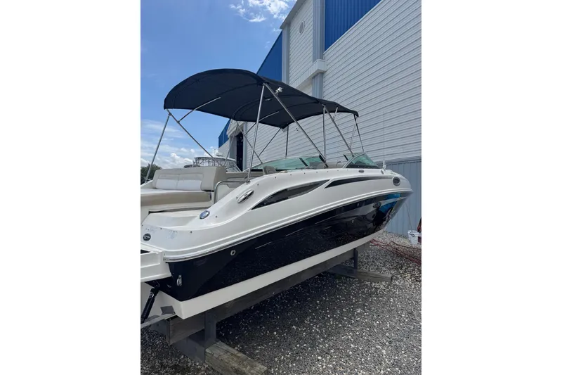 The Image of 2013 Sea Ray 280 Sundeck boat with canopy, docked near a building. - 0