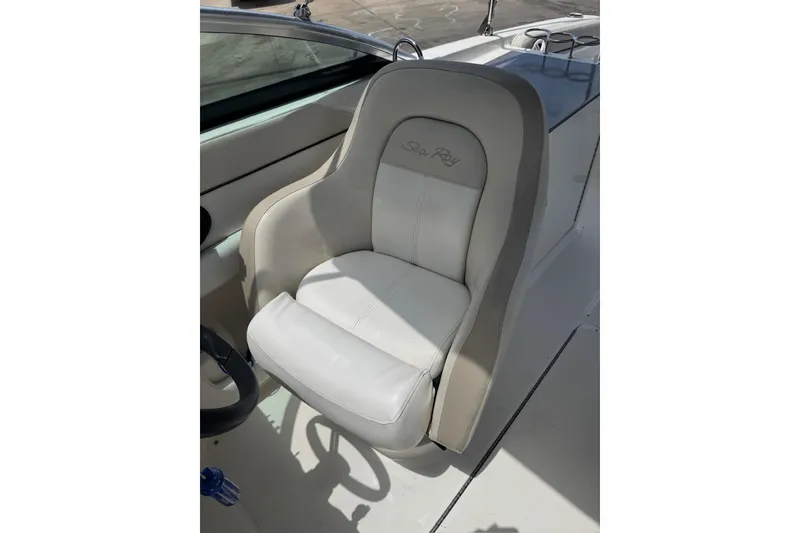 Slide: The Image of Captain's seat on a 2013 Sea Ray 280 Sundeck boat, featuring white upholstery. - 13