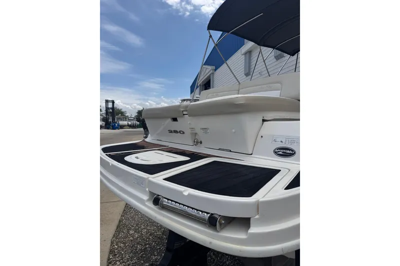 Slide: The Image of 2013 Sea Ray 280 Sundeck boat with swim platform and canopy, docked outdoors. - 22