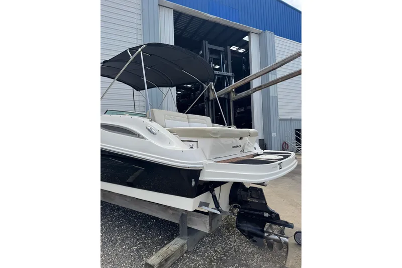 Slide: The Image of 2013 Sea Ray 280 Sundeck boat with canopy, docked near a storage facility. - 28