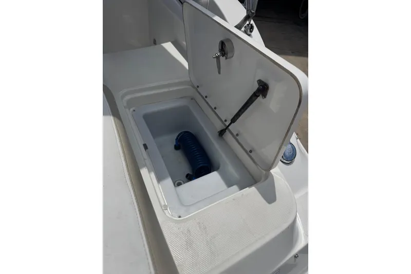 Slide: The Image of Open storage compartment on 2013 Sea Ray 280 Sundeck boat with coiled hose inside. - 33