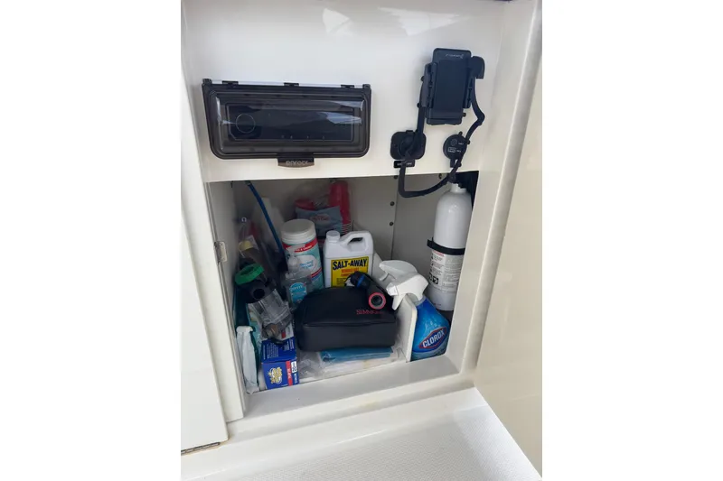 Slide: The Image of Storage compartment on a 2013 Sea Ray 280 Sundeck, filled with cleaning supplies and equipment. - 35