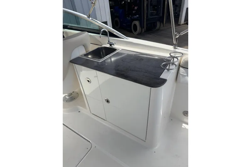 Slide: The Image of 2013 Sea Ray 280 Sundeck boat kitchenette with sink and storage cabinets. - 7