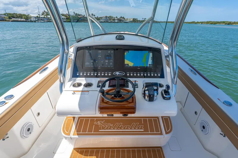 Slide: The Image of 2022 Valhalla Boatworks V-33 helm with advanced navigation system on calm waters. - 14