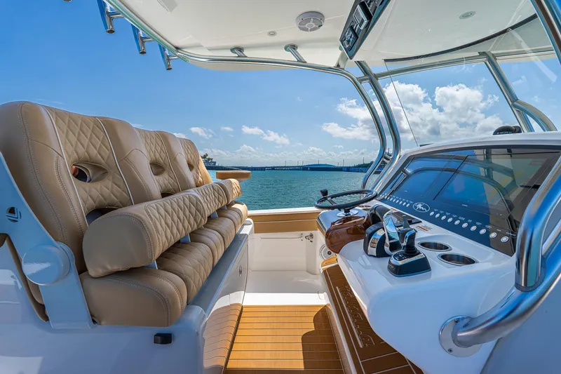 Slide: The Image of 2022 Valhalla Boatworks V-33 helm with luxurious seating and advanced controls, overlooking serene waters. - 18