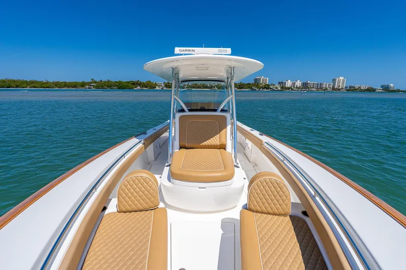 Slide: The Image of 2022 Valhalla Boatworks V-33 on water, featuring tan seating and clear blue skies. - 20