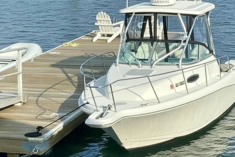 The Image of 2002 Wellcraft 24 Walkaround boat docked by a wooden pier. - 0