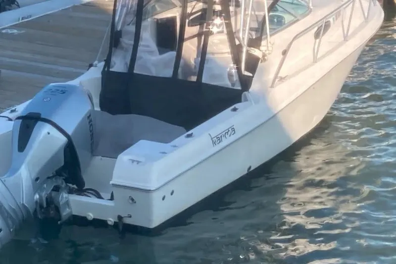 Slide: The Image of 2002 Wellcraft 24 Walkaround boat docked with Honda outboard motor. - 3