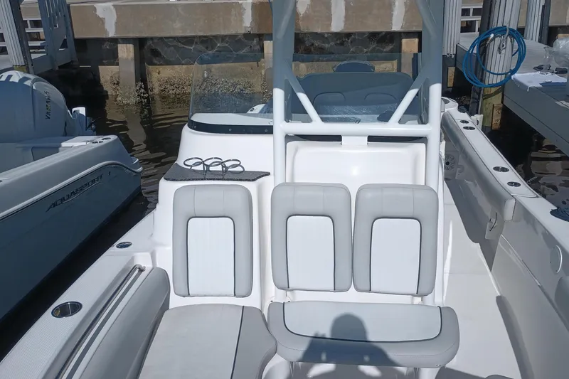 Slide: The Image of 2020 Sea Fox 249 Avenger boat interior with seating and console at dock. - 10