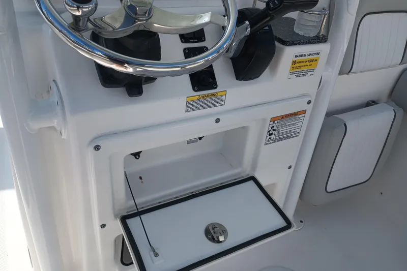 Slide: The Image of 2020 Sea Fox 249 Avenger boat console with steering wheel and storage compartment. - 29