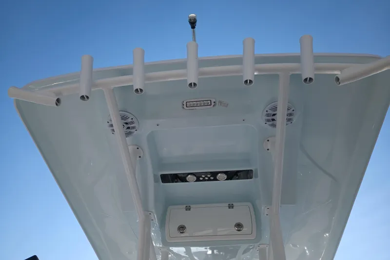 Slide: The Image of 2020 Sea Fox 249 Avenger boat top view with rod holders and speakers against blue sky. - 35