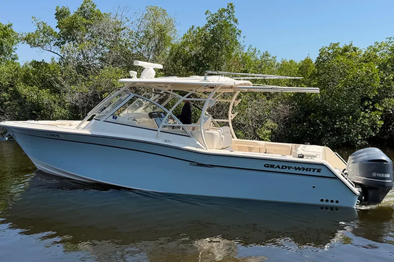 The Image of 2018 Grady-White Freedom 335 boat on calm water, surrounded by lush greenery. - 0
