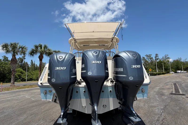 Slide: The Image of 2018 Grady-White Freedom 335 boat with triple Yamaha 300 engines, parked under a clear sky. - 14