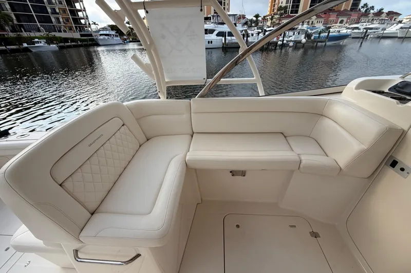 Slide: The Image of 2018 Grady-White Freedom 335 boat interior with luxurious seating in marina setting. - 21