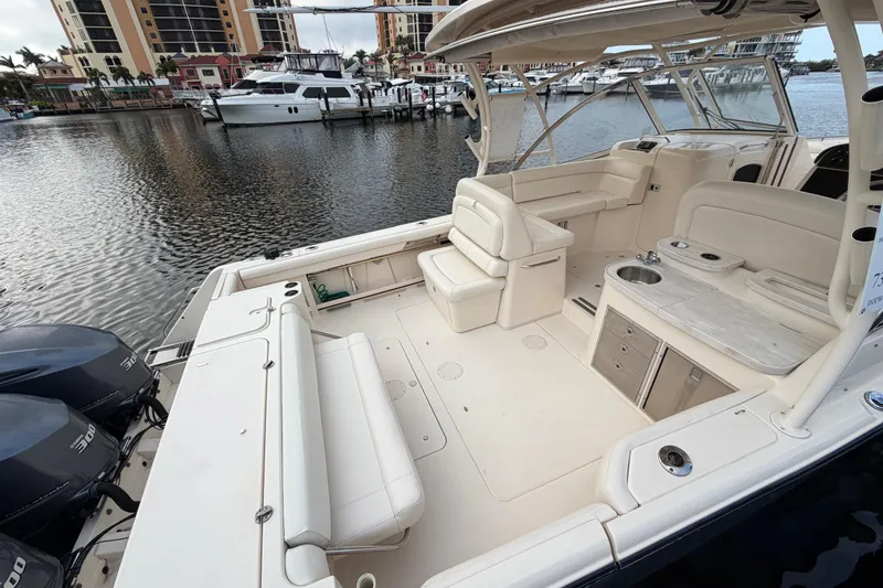 Slide: The Image of 2018 Grady-White Freedom 335 boat interior at marina, showcasing seating and helm. - 23