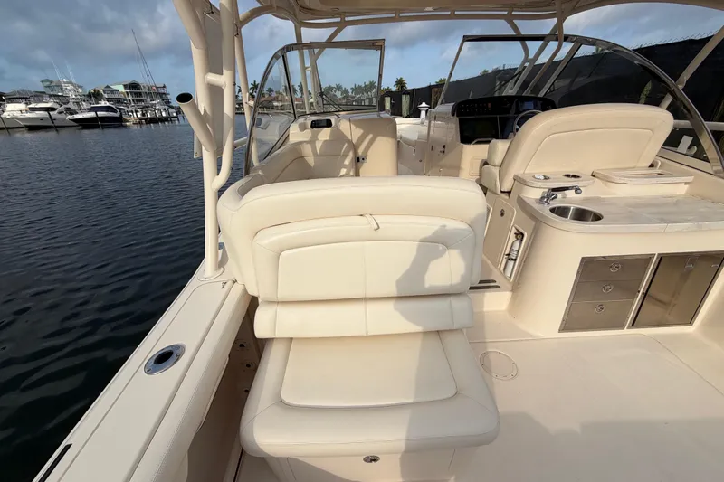 Slide: The Image of 2018 Grady-White Freedom 335 boat interior with seating and storage, docked by the water. - 27