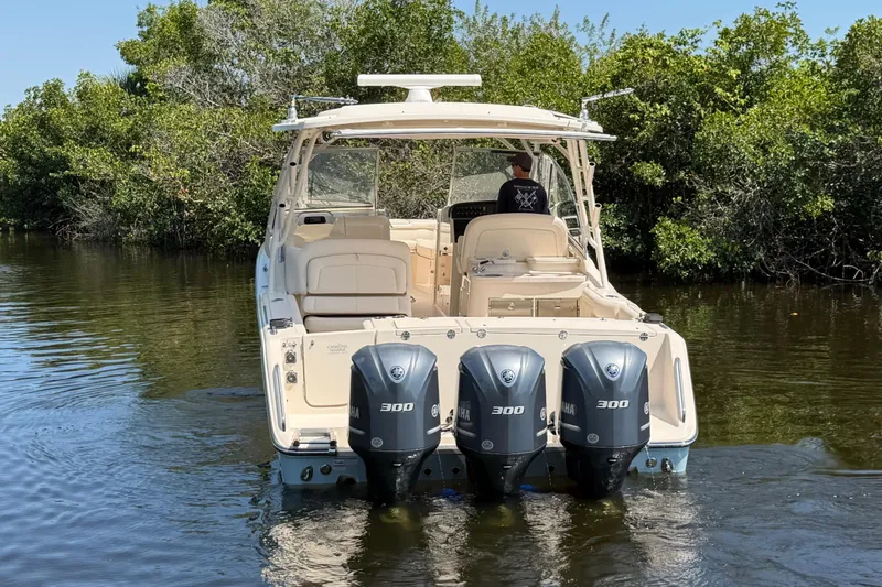 Slide: The Image of 2018 Grady-White Freedom 335 boat with triple Yamaha 300 engines in a serene waterway. - 3