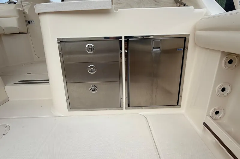 Slide: The Image of Stainless steel storage and fridge on 2018 Grady-White Freedom 335 boat interior. - 30