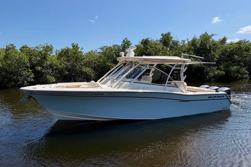 Slide: The Image of 2018 Grady-White Freedom 335 boat on calm water, surrounded by lush greenery. - 5