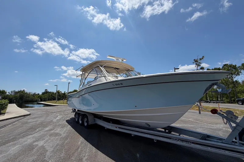 Slide: The Image of 2018 Grady-White Freedom 335 boat on trailer under clear blue sky. - 6