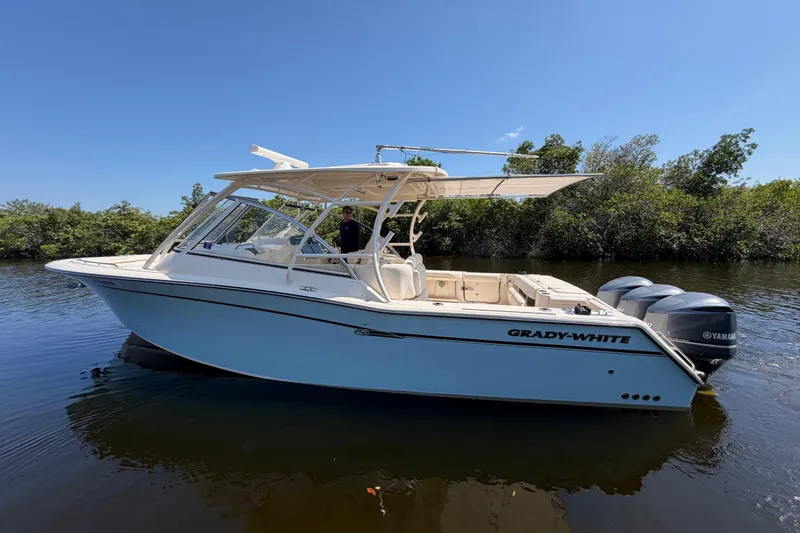 Slide: The Image of 2018 Grady-White Freedom 335 boat on calm water, featuring dual Yamaha engines. - 7