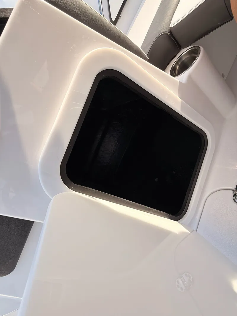 Slide: The Image of Stingray 20 SBX 2026 boat interior with storage compartment and cup holder. - 22