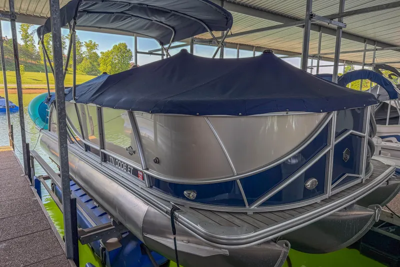 Slide: The Image of 2017 South Bay 523 RS pontoon boat docked with cover in marina. - 2
