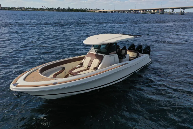 The Image of 2021 Chris-Craft Catalina 34 boat cruising on open water with bridge in background. - 0