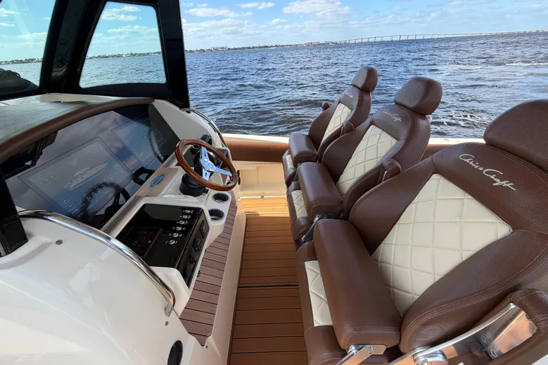 Slide: The Image of 2021 Chris-Craft Catalina 34 interior with luxurious seating and modern dashboard, overlooking the ocean. - 14