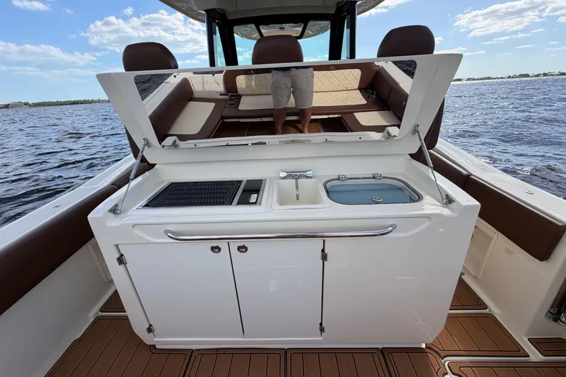 Slide: The Image of 2021 Chris-Craft Catalina 34 boat interior with open kitchenette, sink, and seating area. - 18