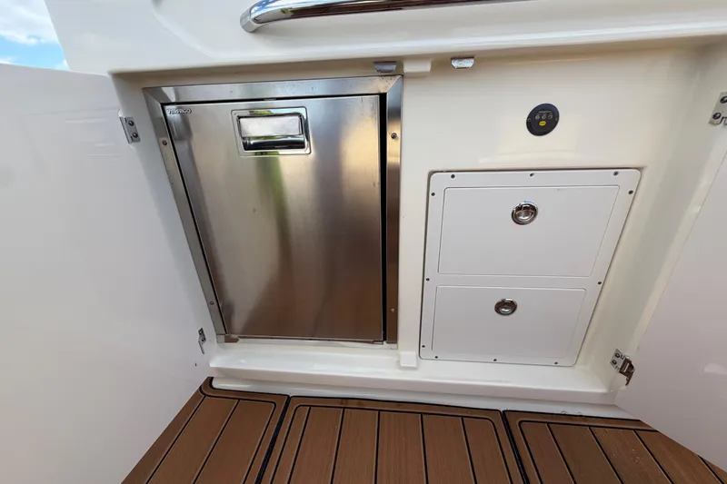 Slide: The Image of 2021 Chris-Craft Catalina 34 interior with stainless steel fridge and storage compartments. - 20