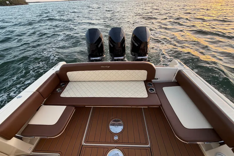 Slide: The Image of 2021 Chris-Craft Catalina 34 boat with triple Mercury engines on water at sunset. - 21